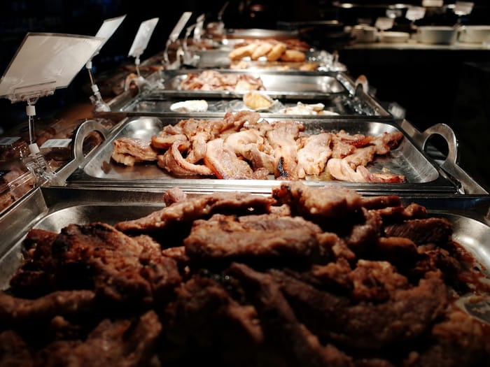 Pečeno meso v gastro posodah na samopostrežnem pultu